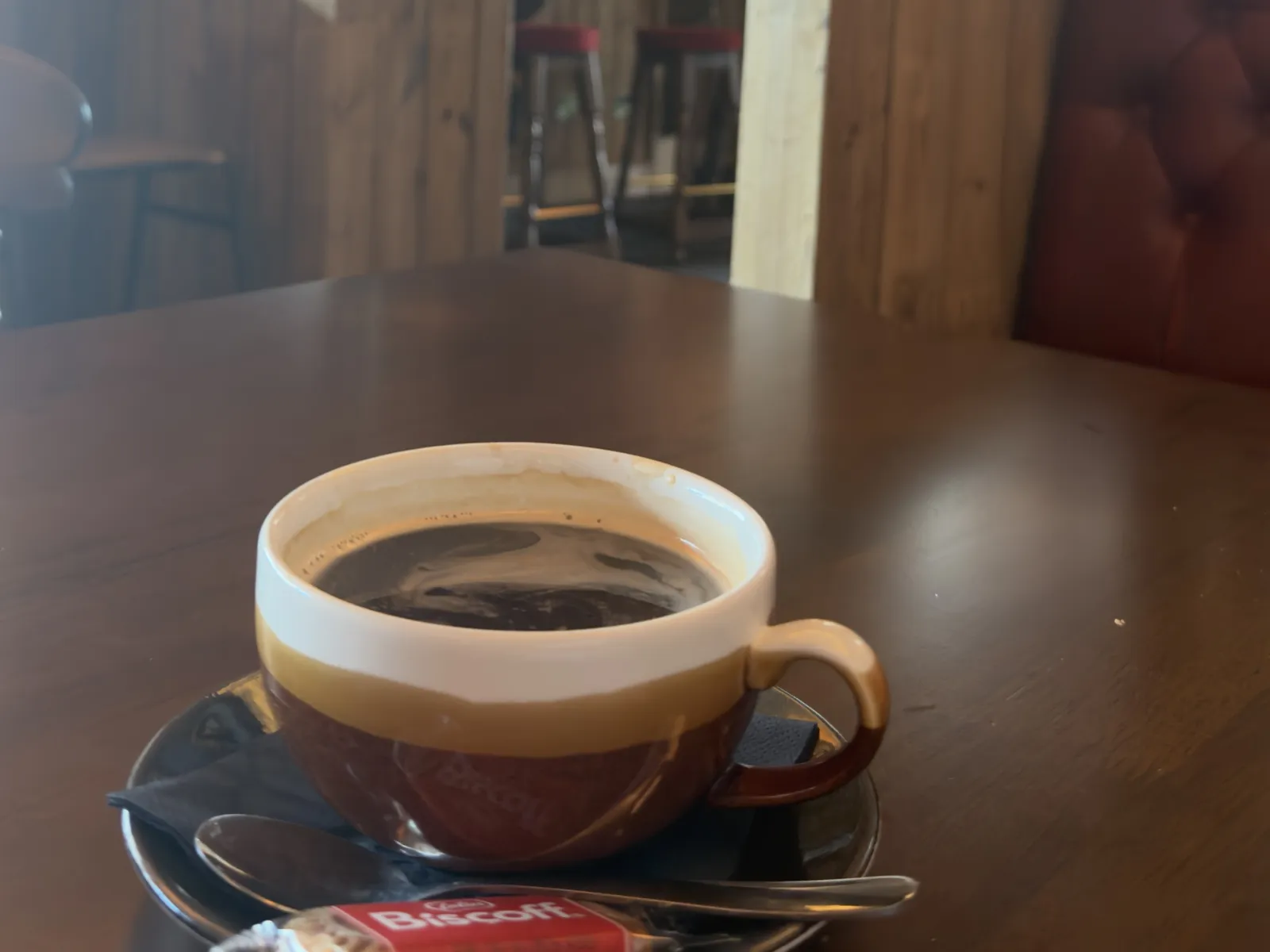 An americano on a wooden table in the morning light